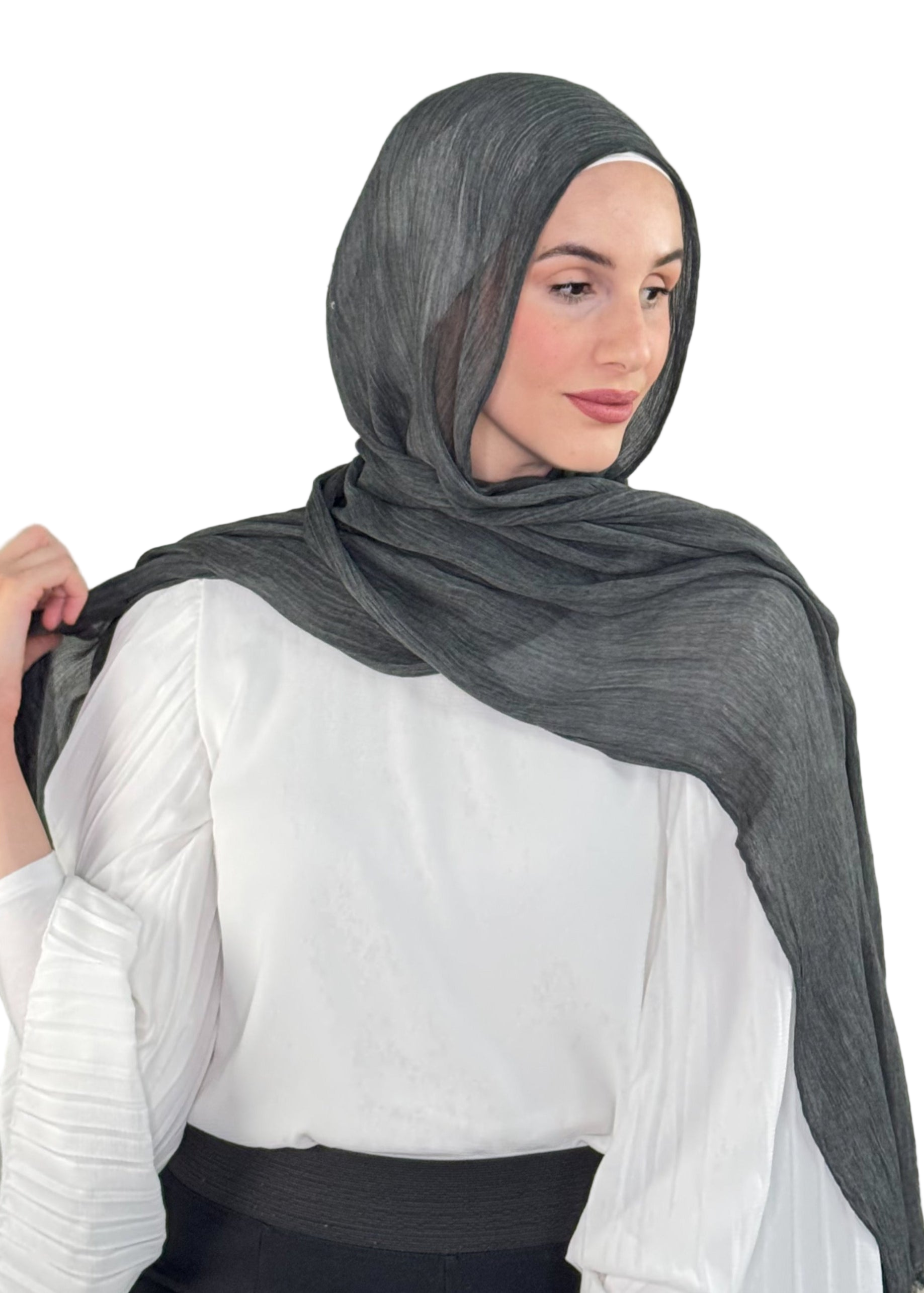 Woman wearing a dark gray hijab and white blouse against a neutral background