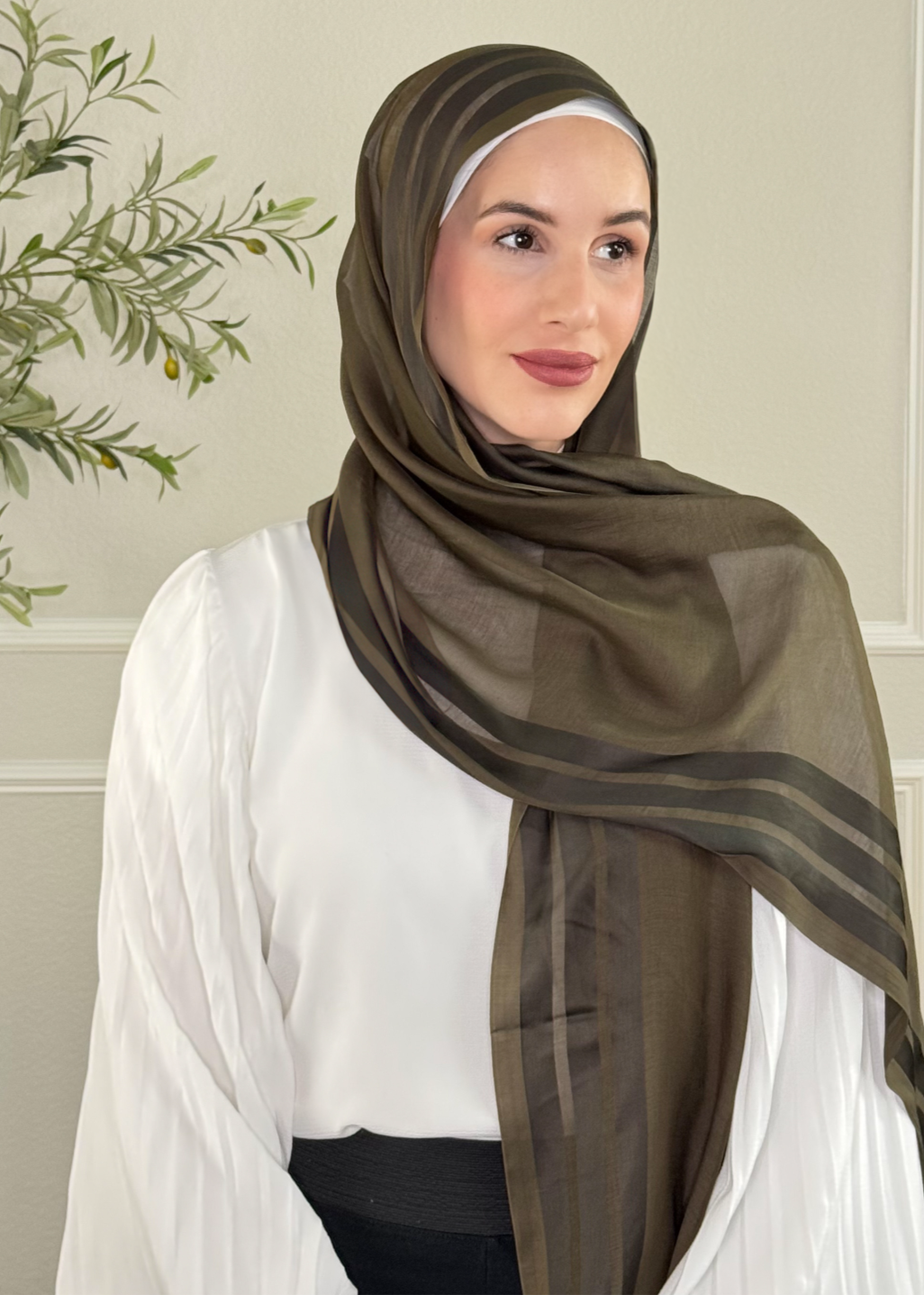 Woman wearing a brown hijab with a white background